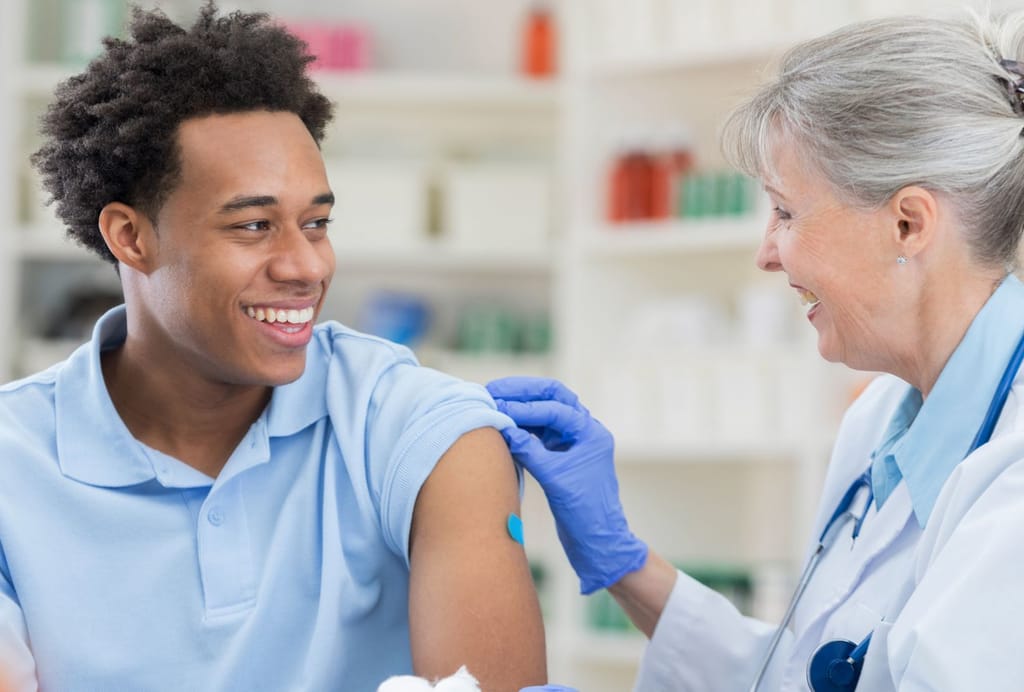 Healthcare professional preparing a patient's upper arm for vaccination